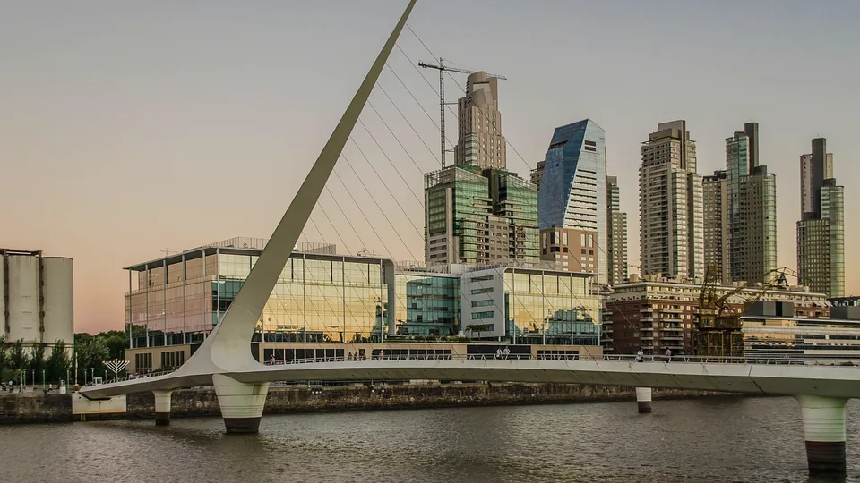 Puerto Madero in Buenos Aires at dusk: the white Puente de la Mujer footbridge and glass towers above the dock.