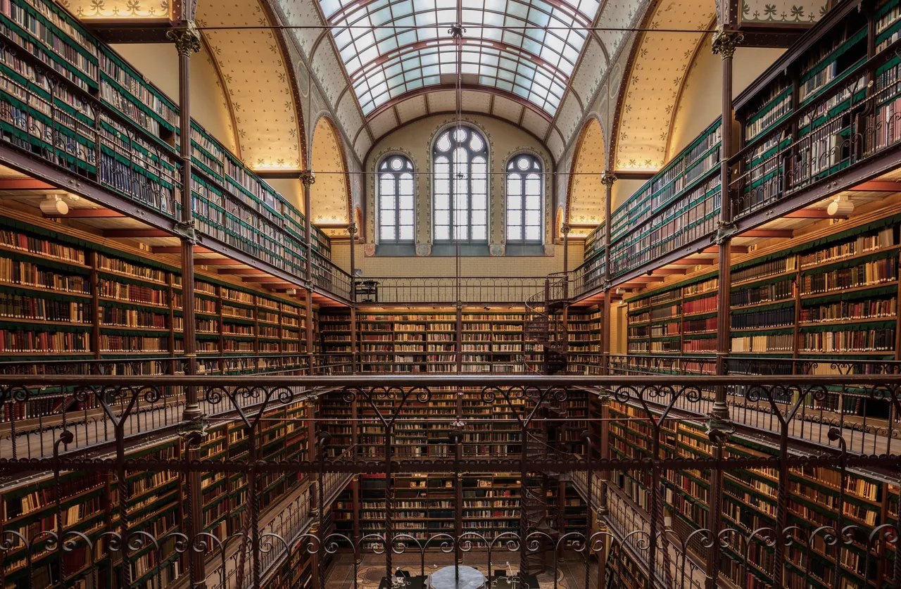 The historic library of the Rijksmuseum in Amsterdam: four levels of book galleries under a glass roof.