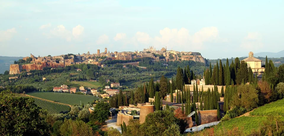 Orvieto on its tufa plateau above vineyards and cypresses.